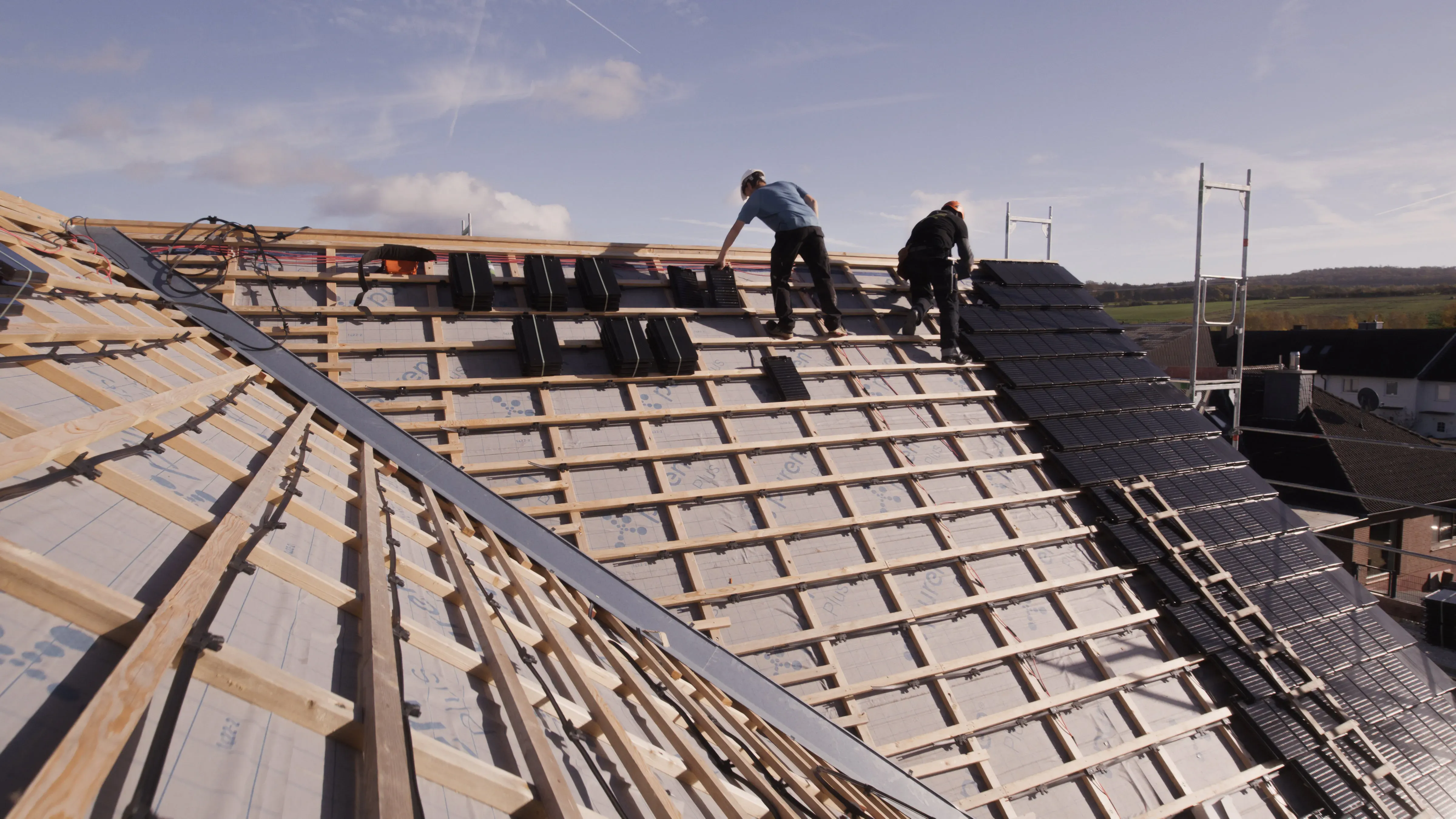 Handwerker auf Dach verlegen Solardachziegel 
