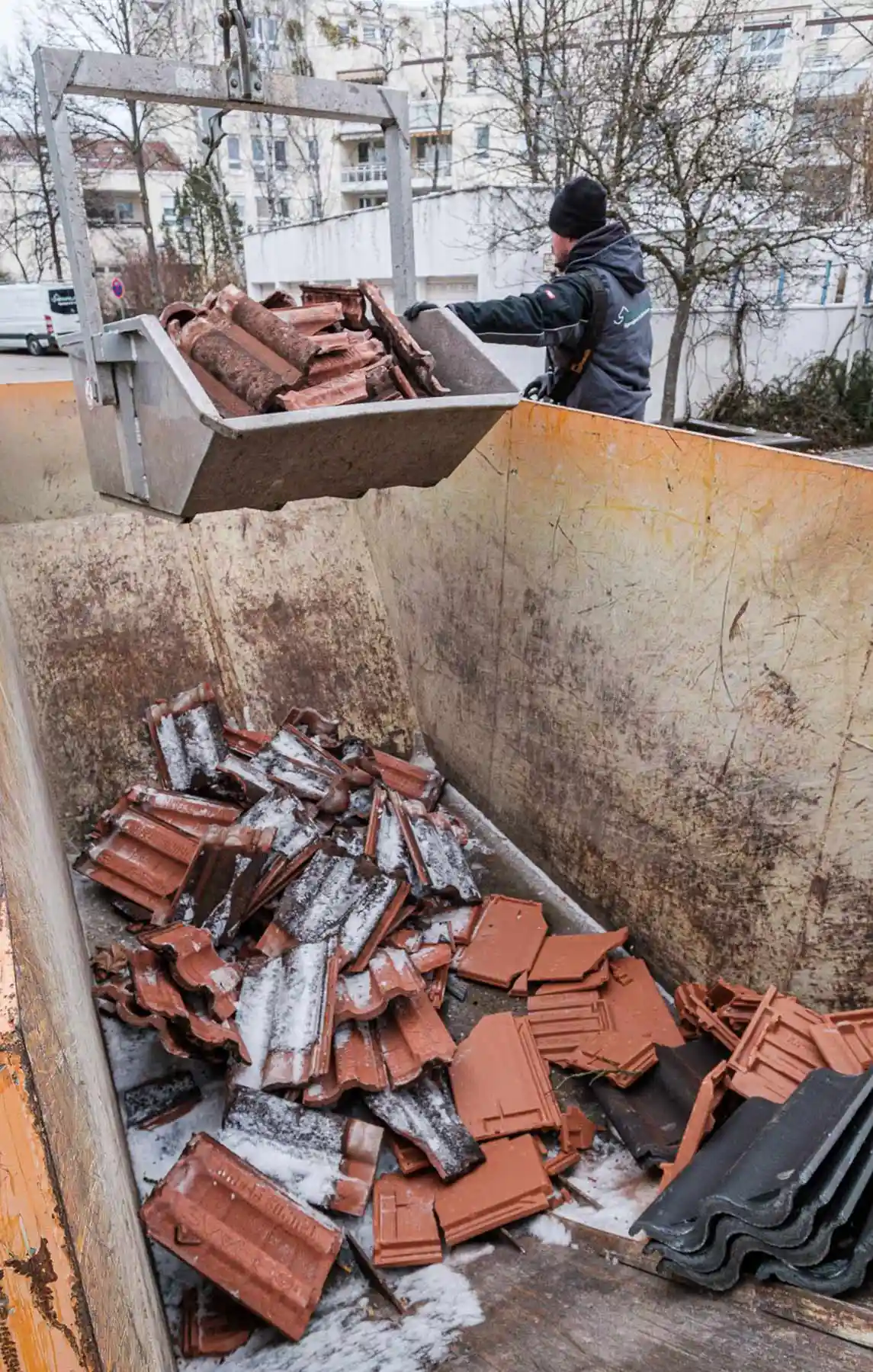 Im Februar 2023 wurden im Schurrweg die alten Betondachziegel vom Dach gerissen und mit Hilfe des Krans in den Container geworfen