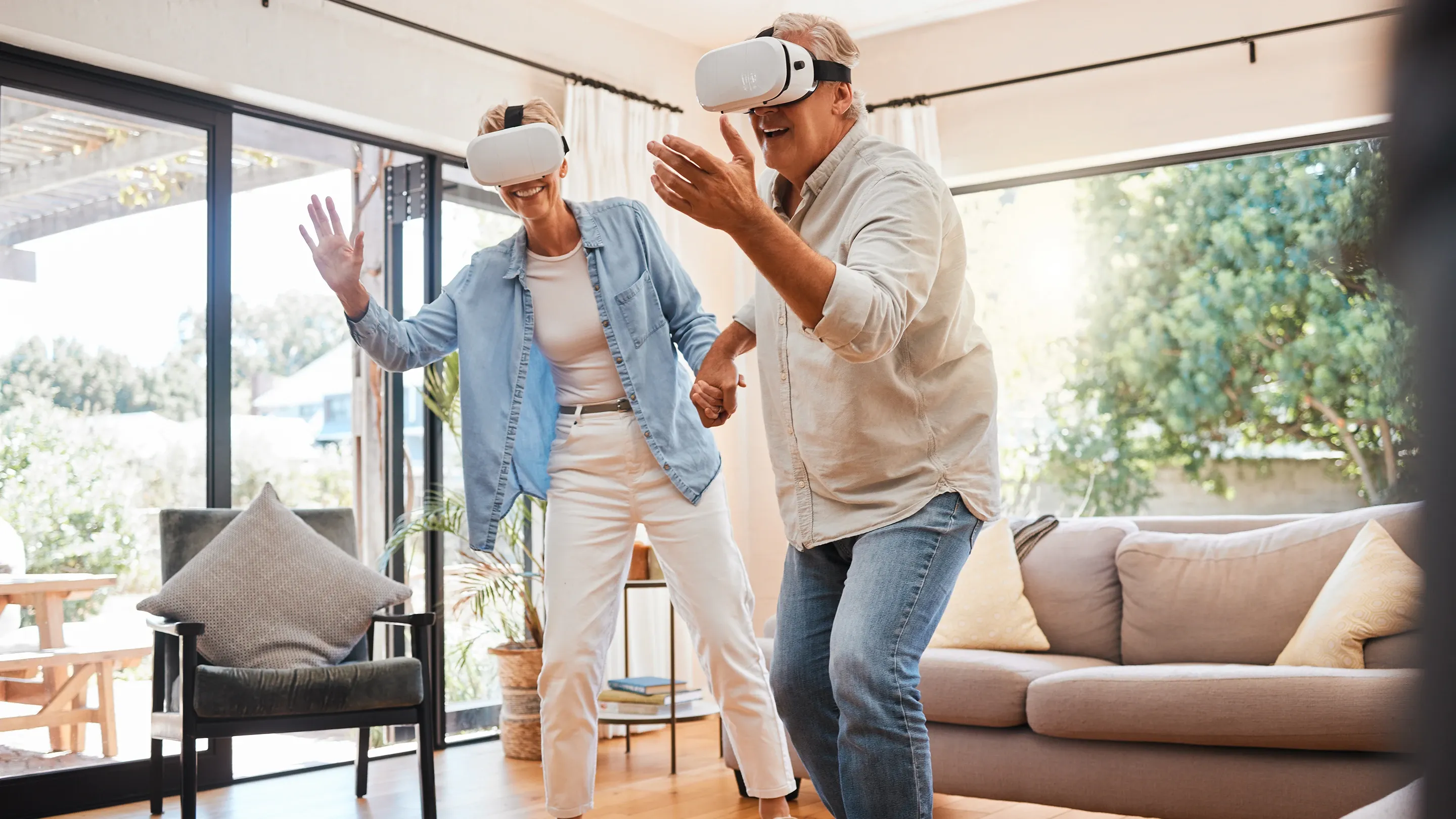 Ehepaar beschäftigt sich mit VR Brillen im Wohnzimmer.