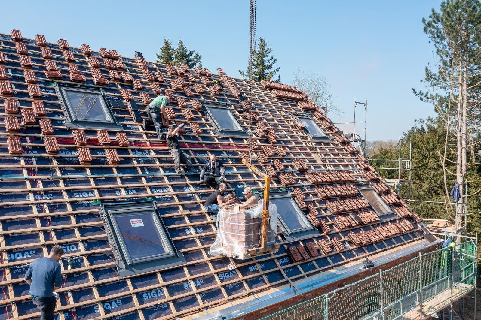 Dachdecker in Aktion auf Dach beim verlegen von Solardachziegel