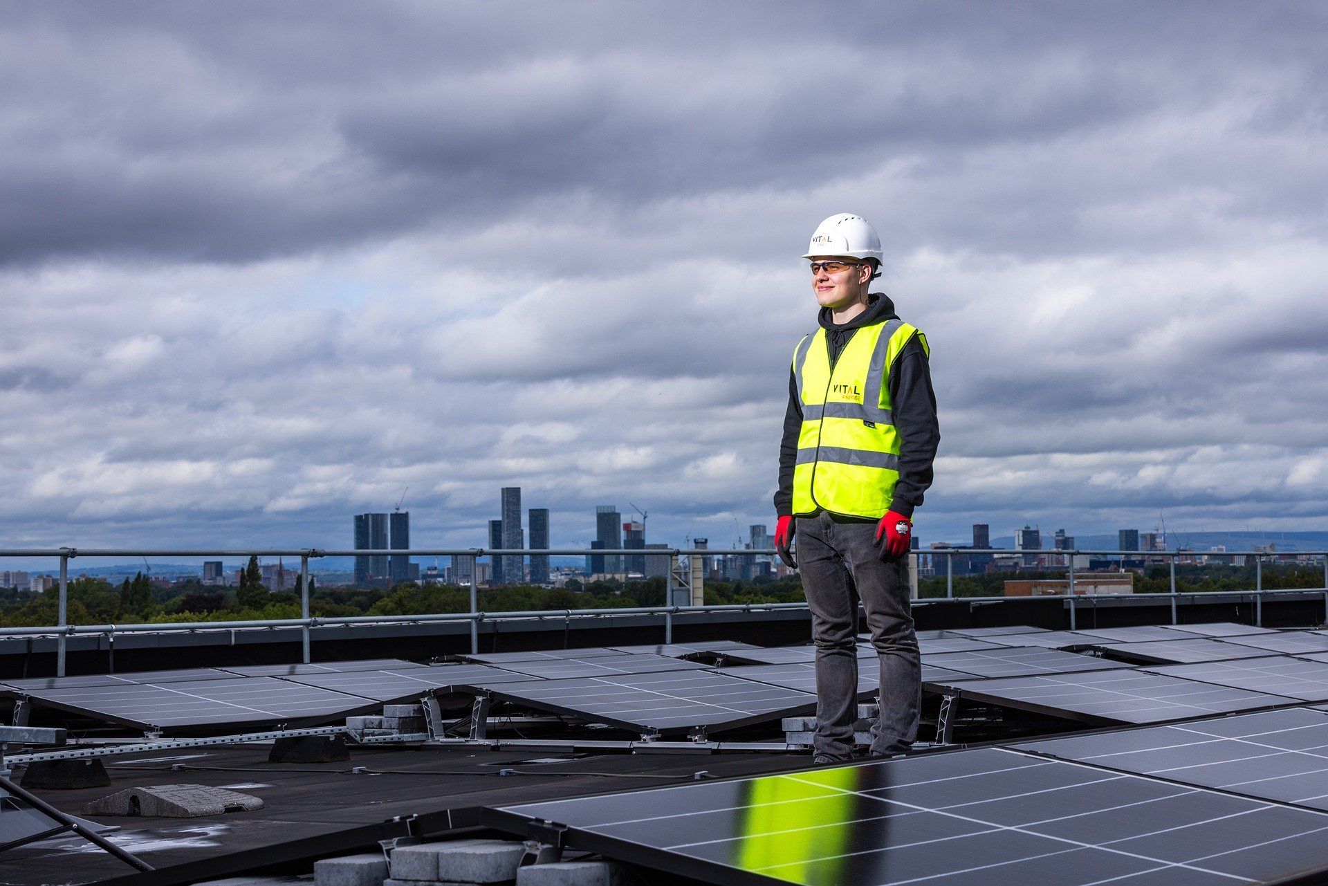 Person mit gelber Warnweste bei der Installation von Solarmodulen